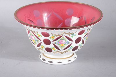 un bol rouge et blanc posé sur une table blanche