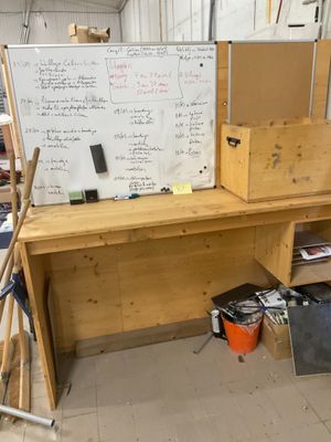 un tableau blanc accroché au mur à côté d'un établi