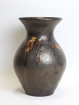 a black vase that is sitting on a white surface