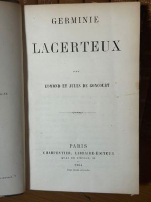 un vieux livre posé sur une table en bois, près d'un mur de briques