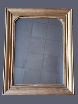 an antique gold framed mirror on a grey background