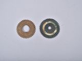 two gears on a white surface one has a hole in the middle
