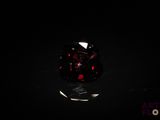 a close up of a red and black ring on a black surface