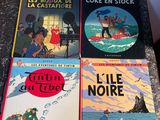 four children ' s books sitting on a table in front of a wall