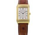 a gold plated rectangular watch with brown leather strap