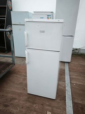un réfrigérateur blanc posé au milieu d'une pièce