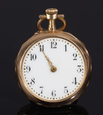 a close up of a gold pocket watch on a black surface