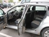 a silver car with its door open in a parking lot