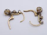 two pairs of gold and diamond earrings on a white surface