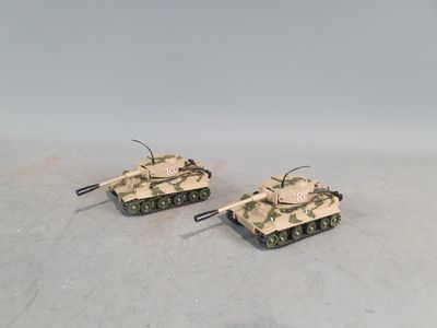 two toy tanks sitting on top of a table next to each other