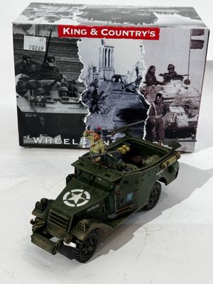 un véhicule militaire miniature posé devant une boîte