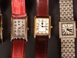 many different types of watches displayed on a black surface