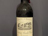 a bottle of wine sitting on top of a wooden table