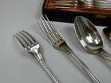 a spoon, fork, and spoon rest on a table