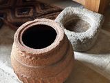 deux pots en terre cuite posés par terre à côté d'une étagère en bois