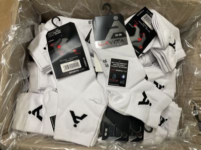 plusieurs paires de chaussettes blanches dans un sac en plastique posé sur une table