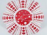 a red and white vase with polka dots on it