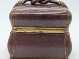 an old brown leather box with a handle on top of it