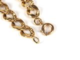 two pieces of gold plated chain on a white surface