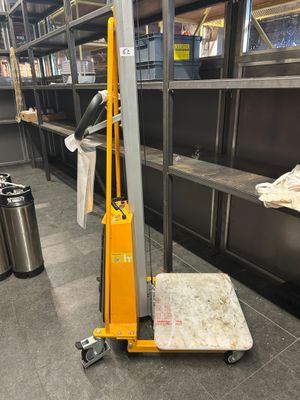a yellow hand truck that is parked in a warehouse