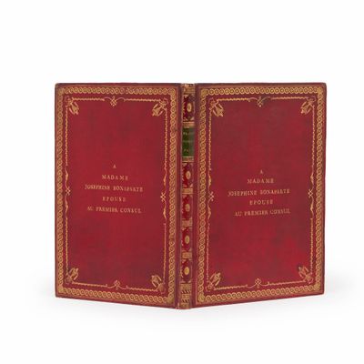 un vieux livre à la couverture rouge posé sur une surface blanche