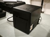 a black box sitting on top of a table next to a black chair
