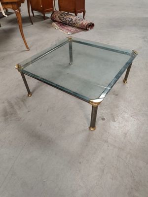 a glass table with a metal frame on it in a room