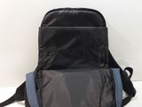 the back of a black and blue backpack sitting on top of a white table