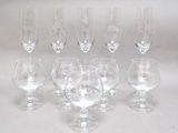 six verres à vin vides sont alignés sur une surface blanche