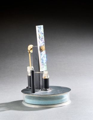 deux stylos et un miroir posés sur une assiette