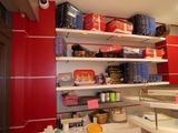 a kitchen with red cabinets and shelves filled with food