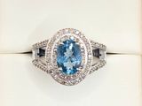 an image of a ring with a blue topaz stone surrounded by diamonds