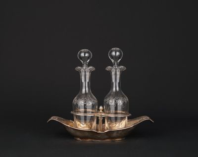 une paire de carafes posées sur un plateau en argent avec un fond noir