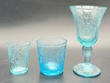 three glasses and a cup sitting on a table