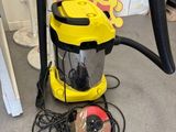 un aspirateur jaune et noir posé par terre à côté d'un objet rouge et jaune