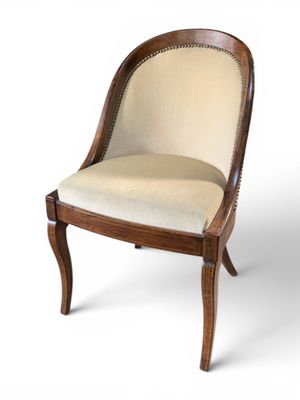a close up of a wooden chair with a beige upholstered seat