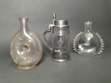 three glass vases and a beer mug on a table
