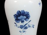 un vase blanc orné d'une fleur bleue
