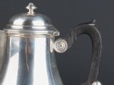 a silver coffee pot sitting on top of a table