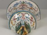 a decorative plate with a fan on it on a table