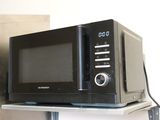 a microwave sitting on top of a shelf with a clock on it
