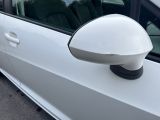 a white car with a side mirror on the side of the road