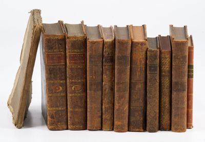 plusieurs vieux livres sont empilés sur une surface blanche