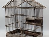 une cage à oiseaux contenant un oiseau, sur fond blanc