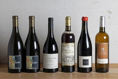 plusieurs bouteilles de vin sont alignées sur une table en bois