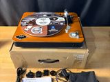 un tourne-disque posé sur une valise, sur une table