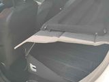 a white car with the door open and the seat folded down