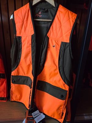 an orange and black vest sitting on top of a shelf next to a red backpack