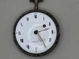 une horloge accrochée au mur et comportant des chiffres romains