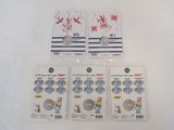 three packs of silver coins are sitting on a white surface